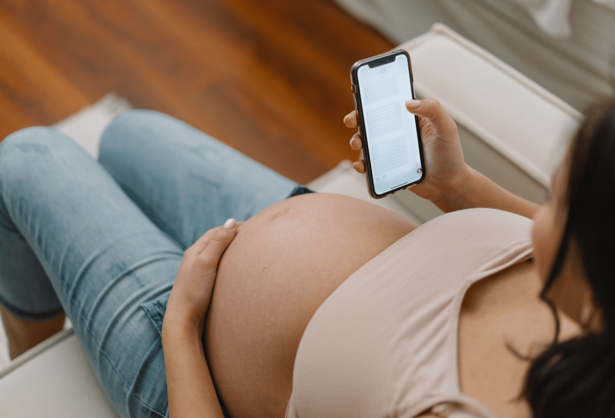 Pregnant lady searching for information on her phone - Anya pregnancy, baby & breastfeeding app