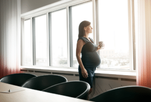 Pregnant lady at the window in a meeting room - Anya pregnancy, baby & breastfeeding app