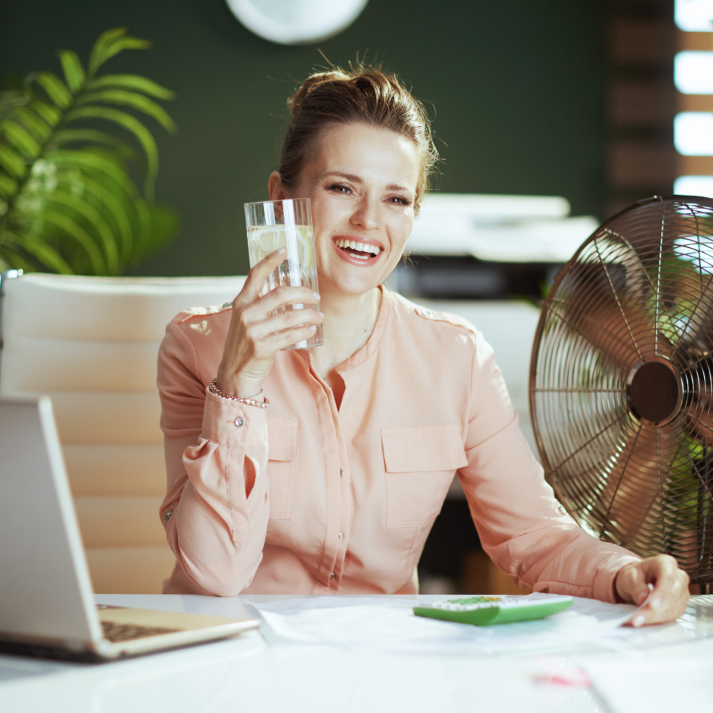 Menopause Support for Employers' in the UK. Woman with fan and cold water